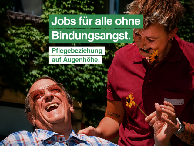 Eine Pflegerin im Caritas-T-Shirt steht neben einem älteren Herren, der im Rollstuhl sitzt. Beide lachen. Als Text im Bild steht: "Jobs für alle ohne Bindungsangst. Pflegebeziehung auf Augenhöhe."