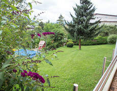 Die Gartenanlage mit einer schönen Wiese, Sträuchern und Bäumen laden zum Wohlfühlen ein.