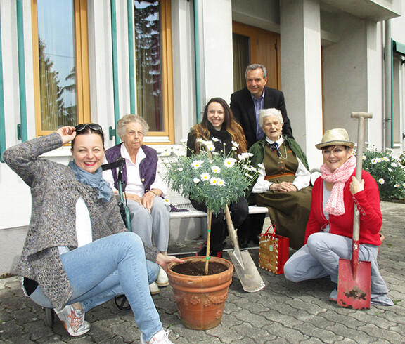 Freiwillige Helfer aus dem Büro X mit Bewohnerinnen im Garten des Haus St. Klemens