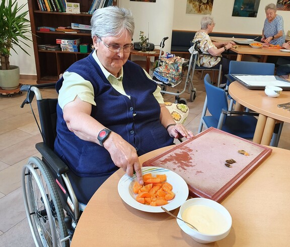 Ältere Dame beim Schneiden der Marillen.