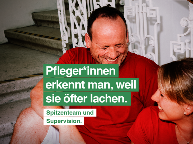 Ein Mann und eine Frau mit roten T-Shirts mit Caritas-Logo sitzen auf den Stiegen und lachen gemeinsam. Die Frau hat einen Aktenordner in der Hand. Text im Bild: Pfleger*innen erkennt man, weil sie öfter lachen. Spitzenteam und Supervision."