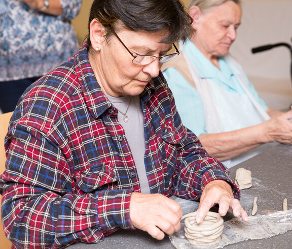 Besucherin aus der Nachbarschaft beim Töpfern im Haus Franz Borgia