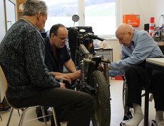 Tagesgast Otmar Schober, Haustechniker Georg Ponzer und Bewohner Fritz Brandl werkeln am Motorrad in der Werkstatt