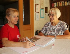 Caritas Mitarbeiterin der Hauskrankenpflege führt Beratungsgespräch mit Angehöriger