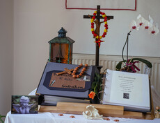 Traueraltar mit Verabschiedungsbuch, Christuskreuz, 2 Engel, Engel-Postkarte, Grablaterne und einer Blume.