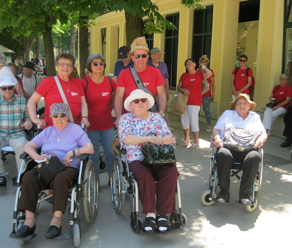 Gruppenfoto von Bewohner*innen vom Haus St. Martin, welche gemeinsam mit Betreuer*innen im roten Caritas-T-Shirts in Schönbrunn unterwegs sind.