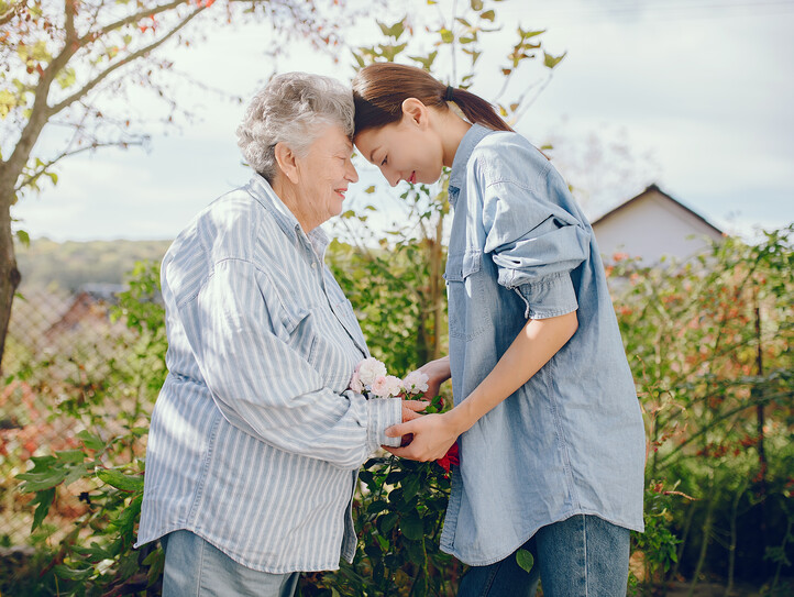 Old woman in a garden with young granddaughter