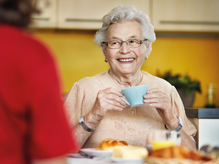 Ältere Dame beim Frühstück zu Hause